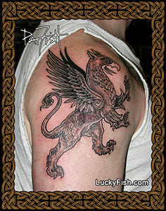 Tattoo of a winged creature rampant griffin on a person's arm with 'Lucky Fish.com' branding.