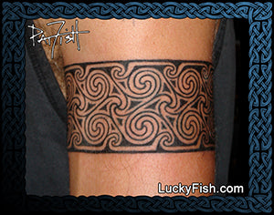 Tattoo design of Pictish spirals on a person's arm with 'Lucky Fish' branding.
