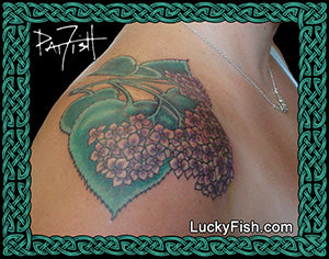 Tattoo of a hydrangea floral design on a person's shoulder with 'Lucky Fish' branding.