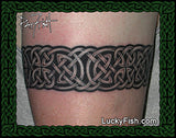 Celtic knot tattoo on a person's arm with Lucky Fish.com branding.