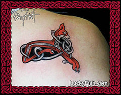 Tattoo of a red and black Celtic dog knot design on skin, with Lucky Fish branding.