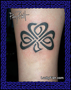 Black tribal tattoo of a Celtic knot shamrock on a person's arm with 'Lucky Fish' branding.