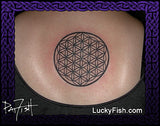 Tattoo of a flower of life symbol on a person's back with 'Lucky Fish' branding.