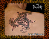 A black and gray Celtic knotwork tattoo design on human skin, shown with a decorative border and the text LuckyFish.com and signature of artist Pat Fish