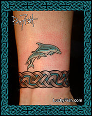 Tattoo of two dolphins and Celtic knot band design on a person's ankle, with Lucky Fish branding.