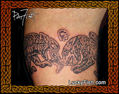 Tattoo of two battling Pictish animals on a person's arm with 'Lucky Fish' branding.