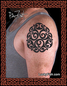 Tattoo of a black intricate design on a person's arm with 'Lucky Fish' branding.