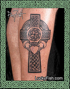 Celtic cross tattoo with claddagh and heart on a person's leg with Lucky Fish branding.