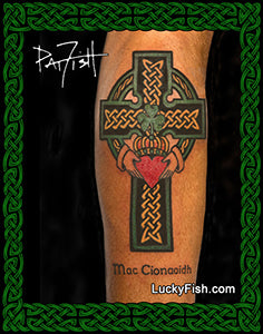 Celtic cross tattoo on a person's leg with intricate designs and text, framed by green Celtic knotwork.