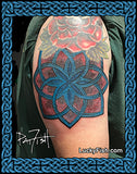 Tattoo of a colored lotus coverup Celtic knot design on a person's arm, with 'Lucky Fish' branding.