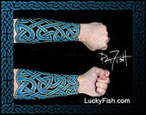 Celtic knot tattoo design on a forearm with  'LuckyFish.com' branding.