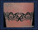 Black tribal tattoo on a person's arm with 'Lucky Fish' branding.