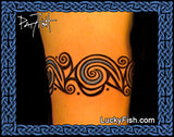 Tattoo of a Celtic design on a person's arm with 'LuckyFish.com' branding.