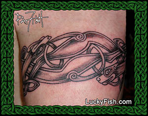Tattoo of Celtic dog design on arm with 'Lucky Fish' branding.