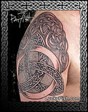 Celtic knot tattoo on a person's arm with 'Lucky Fish' branding.