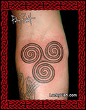 Triskele tattoo on a person's arm with 'Lucky Fish' branding.