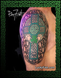 Colorful Celtic cross knot tattoo on a person's arm with 'Lucky Fish' branding.