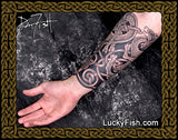 Tattooed arm with intricate Celtic dog designs and featuring LuckyFish.com branding.