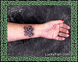 Hand with a tattoo of a  Celtic knotwork heart 