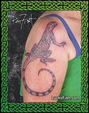 Tattoo of a lizard on a person's arm with 'Lucky Fish' branding.