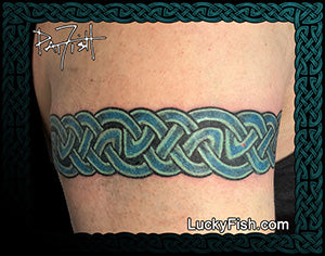Tattoo of a blue Celtic knot design on a person's arm with 'Lucky Fish' branding.