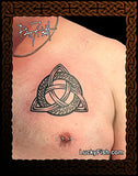Tattoo of a Celtic knot design of a knotwork ring and triquetra on a person's chest with 'Lucky Fish' branding.