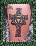 Celtic cross tattoo on a person's arm with decorative green triangle and 'Lucky Fish' branding.