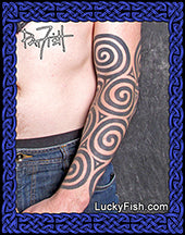 Tattoo of a Pictish tribal bold spiral design on a person's arm with 'Lucky Fish' branding.