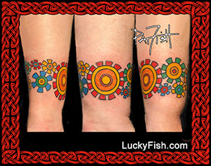 Colorful circular tattoos on a person's arm with 'Lucky Fish' branding.