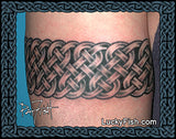 Celtic knot arm band knotwork tattoo on a person's arm with LuckyFish.Com branding.
