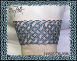 Celtic knot armband tattoo on a person's arm with 'Lucky Fish' branding by Pat Fish