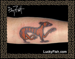 A tattoo design of a hunting hound from the Book of Kells on a person's forearm.