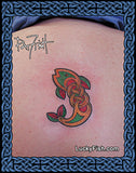 Tattoo of a colorful Celtic knot design of a fish on skin with 'Lucky Fish' branding.