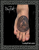 Tattoo of a Celtic knot design of three salmon fish on a person's foot with 'Lucky Fish' branding.
