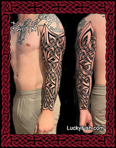 Person with Celtic tribal sleeve tattoos on arms, framed with LuckyFish.com branding