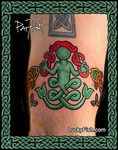 Tattoo of a green and red mermaid and fish design on a person's arm with Lucky Fish branding.