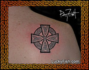 A black Celtic-style cross tattoo on human skin, framed by an ornate gold and brown border with the text LuckyFish.com and a Pat Fish signature in the top right.