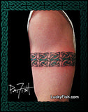Tattoo of a Celtic knot design armband on a person's arm with 'Lucky Fish' branding.