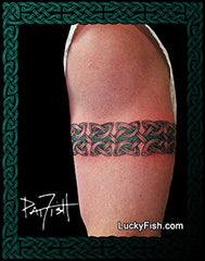 Tattoo of a Celtic knot design armband on a person's arm with 'Lucky Fish' branding.