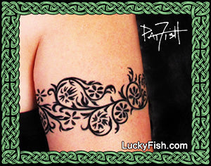 Black floral tattoo on a person's arm with 'LuckyFish.com' branding.
