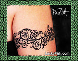 Black floral tattoo on a person's arm with 'LuckyFish.com' branding.