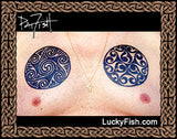Two spiral Celtic tattoos by Pat Fish on a chest with 'LuckyFish.com' branding.