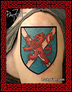 Tattoo of a red lion on a blue Scottish Saltire Flag shield with a Celtic knot design border, featuring LuckyFish.com branding.