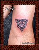 Celtic knot tattoo on a wrist with Lucky Fish tattoo studio branding.