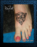 Tattoo of a triangular Celtic knot design on a foot with 'Lucky Fish' branding.