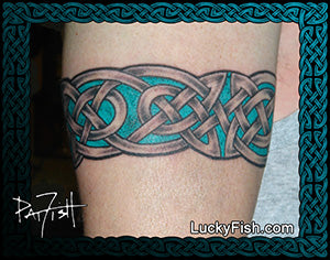 Celtic knot tattoo arm band by Pat Fish on a person's arm with 'Lucky Fish' branding.
