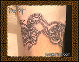 Celtic knot tattoo on a person's arm with Celtic cats from the Book of Kells and 'LuckyFish.com' branding.