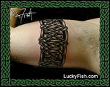 Inner arm view of Celtic knot armband tattoo with 'Lucky Fish' branding.