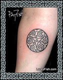 Tattoo of a Celtic spiral design on a person's arm with 'Lucky Fish' branding.