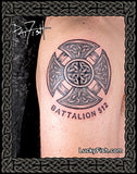 Tattoo of a Celtic cross design on a person's arm with 'Battalion 512' text, against a black background with decorative patterns.
